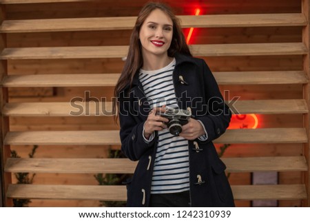 Happy young hipster woman holds retro photo camera