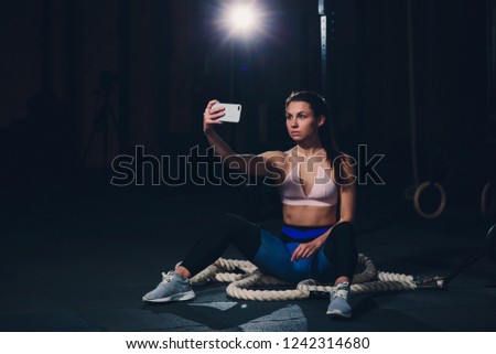 sport woman smile at camera self picture at gym, young girl picture herself exercising fitness center.
