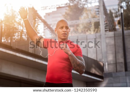 Sports exercise. Nice good looking man holding his hand up while doing a sports exercise
