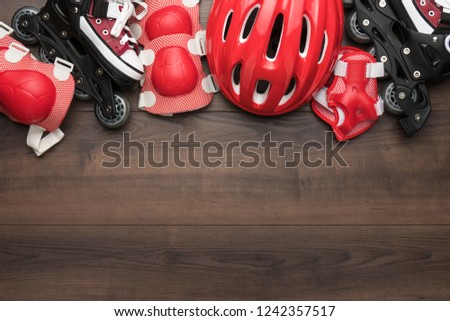 roller skates and body parts protection on brown table with copy space
