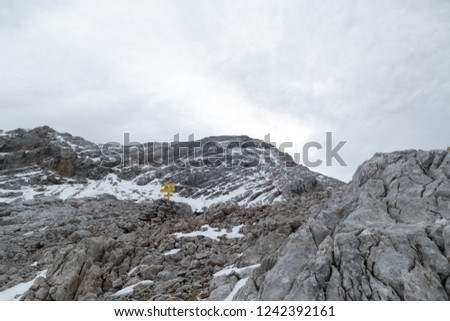 a grey rock with snow in the alps in the early winter