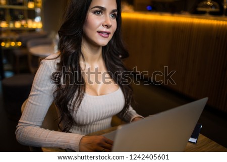 Smiling gorgeous woman professional web content writer for fashion magazine thinking about new work ideas while sitting with laptop computer in coffee shop. Female dreaming during online webinar 