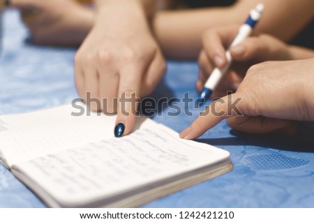 Woman is writing a notes in a notebook and plans daily schedule, close up photo.