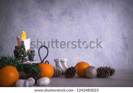 Christmas or New Year composition with a candle, tangerines, and Christmas decorations, pine cones, a place for text. holiday composition of the new year.