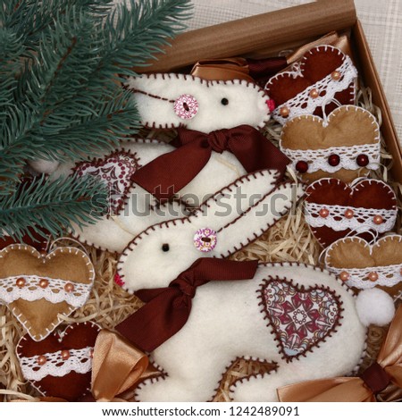 Different textile handmade felt toys - hares, rabbits, harts, birds on christmas tree in paper box. Gift for christmas holidays.