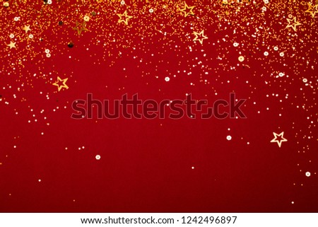 Gold falling sparkles on red background. Festive concept.