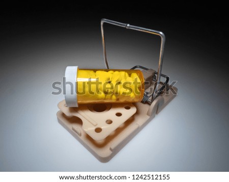 Trap with medical bottle full of pills. Drug addiction concept