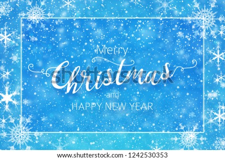 Christmas & winter greeting card. Merry Christmas handwritten callighraphy text with snow falling on blue background.
