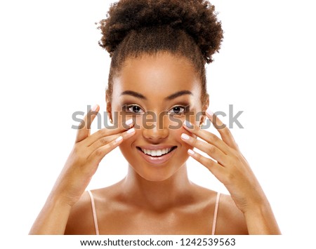 Attractive woman doing facial massage. Photo of african american woman with clean healthy skin on white background. Skin care and beauty concept