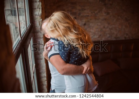 Couple hugging near the window