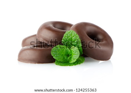 Chocolate donut cookies with green mint leaves on white background.