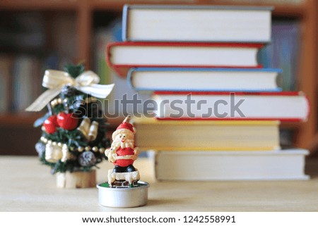 Candle Santa Claus on table in library a small Christmas tree is the background selective focus and shallow depth of field