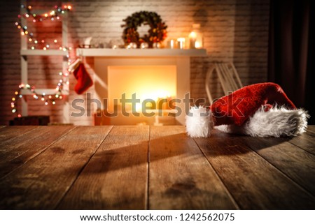 wooden table with attributes of Christmas in the glow of the fireplace 