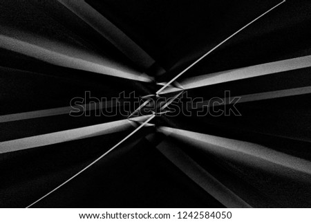 Grunge close-up photo of modern building fragment with optical effect of refracting prism in center of composition. Abstract architecture with sloped girders. Chiaroscuro background in black and white