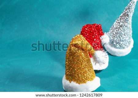 Santa Claus hats glitter isolated golden red silver color on blue background, copy space for text.