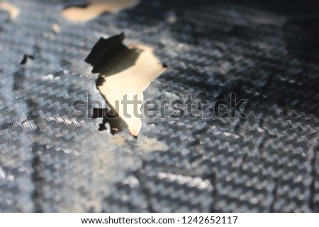 Texture of carbon kevlar fiber material that peel and tear damaged.
Heat protector on the bonnet stripping and tearing damaged.