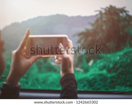 The hands of the women holding the mobile phone are going to take a picture of beautiful view, blur concept.