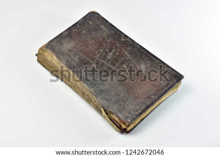 Old book with leather cover aged over hundred years, shot on white background,inclined angle.
