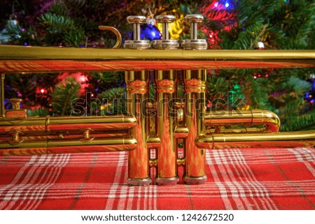 Seasonal holiday musical instrument trumpet with Christmas tree background