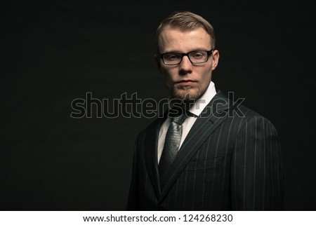 Fashion man in suit wearing glasses. Studio shot.