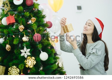 Christmas and New Year preperations. Asian and Friends decorate Christmas tree.