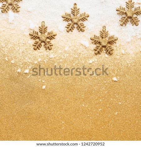Beautiful christmas golden snowflake deco over powdery snow on golden glitter background. Flat lay design. Copy Space. Square crop.