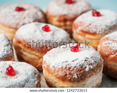 Hanukkah food doughnuts with jelly and sugar powder on blue background. Jewish holiday Hanukkah concept and background. Copy space for text. Shallow DOF