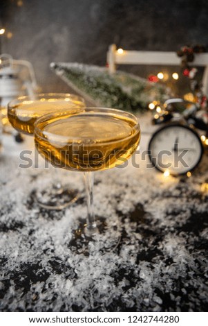 Picture of two wine glasses on blurred background with Christmas tree, lantern, clock