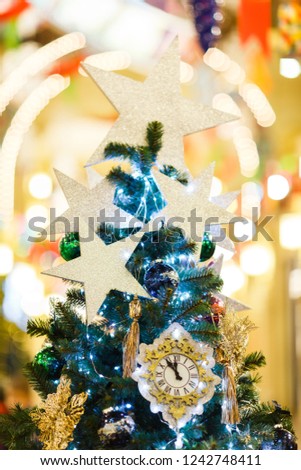 Picture of decorated Christmas spruce with clock, blue balls in store .