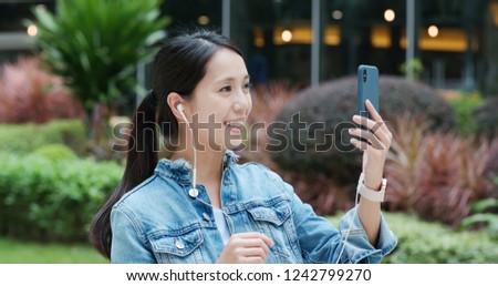 Woman talk to smart phone with earphone