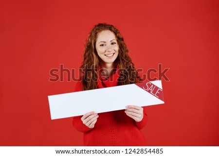 Smiling girl showing empty banner of sale 