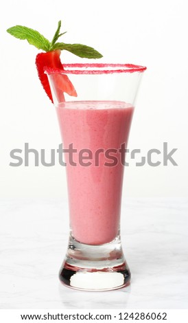 A strawberry smoothie on a a marble surface and white background.