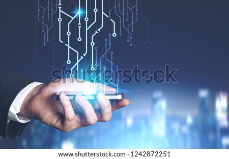 Hand of businessman holding smartphone with circuits emerging from it over night cityscape background. Toned image double exposure mock up Royalty-Free Stock Photo #1242872251