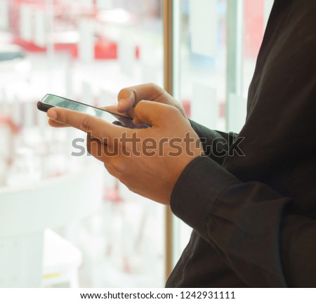 Young business people exchange messages with friends using a free internet connection on a smartphone. Concepts Technology and Communication  In everyday life.