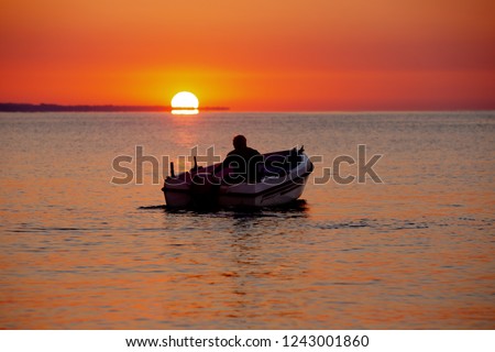 sunrise in the sea and fisherman goes to morning fishing on boat 
