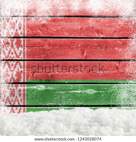 Winter background with wooden wall, falling snow, snowdrift and Belarusian flag