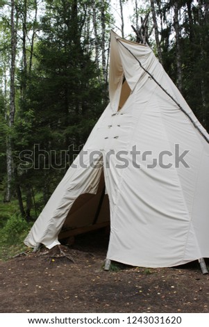 tall wigwam from dense beige fabric in the forest of Karelia Royalty-Free Stock Photo #1243031620