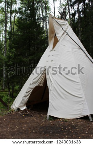 tall wigwam from dense beige fabric in the forest of Karelia Royalty-Free Stock Photo #1243031638