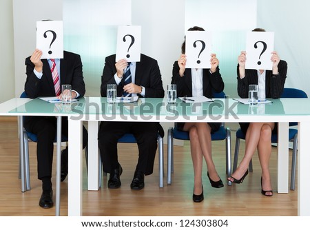 Row of businesspeople with question marks signs in front of their faces Royalty-Free Stock Photo #124303804