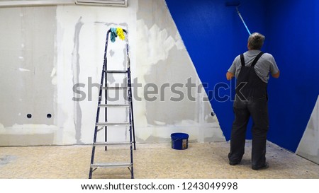 The roller paints the wall blue.worker, vacancy