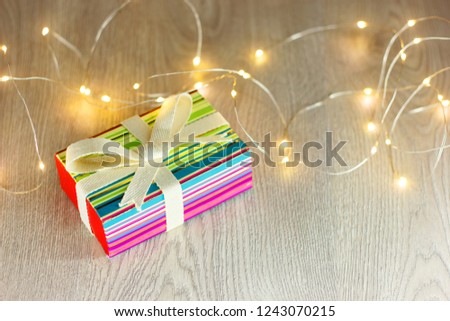 The gift is in a beautiful box with a luminous garland.