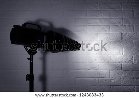 Professional photo studio lighting equipment near brick wall. Space for text