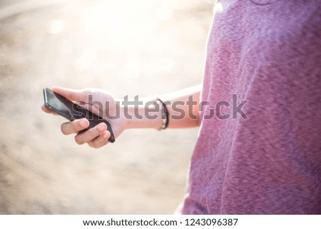 woman's hand holding texting white cell phone at outdoor with copy space,blank screen for text.concept for business,people communication,technology electronic device.modern life style