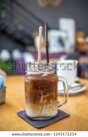 Cup of Ice Latte coffee on wooden table	