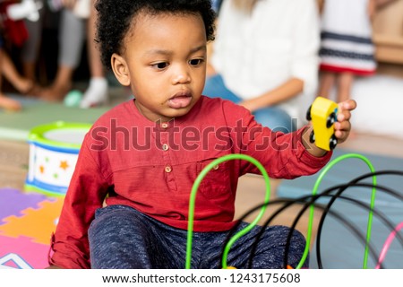 Little boy playing toys in the playroom Royalty-Free Stock Photo #1243175608