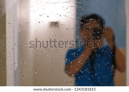 Photographer taking selfie on a wet grass in bathroom