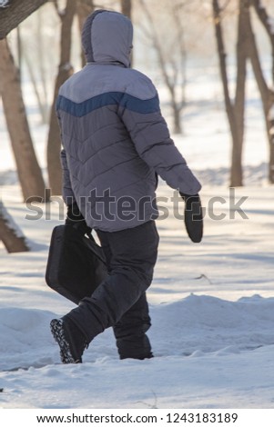 man walking in the snow, rear view