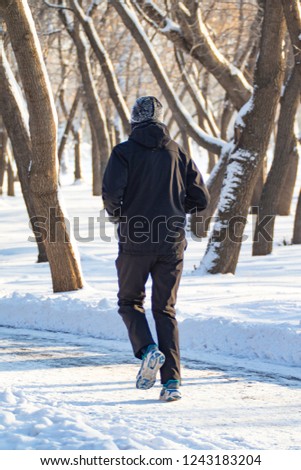 man walking in the snow, rear view