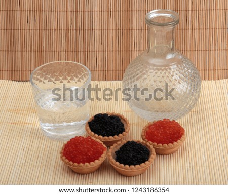 Fish caviar in a plate on a wooden background
