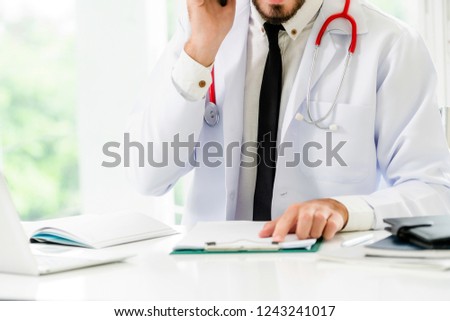 Doctor at office table in the hospital with patient health file. Medical and healthcare concept.